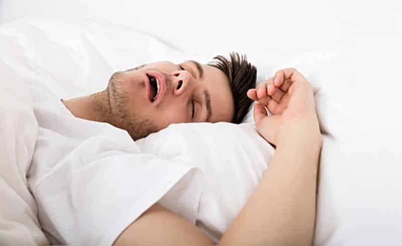 Gambar seorang pria sedang mendengkur saat tidur