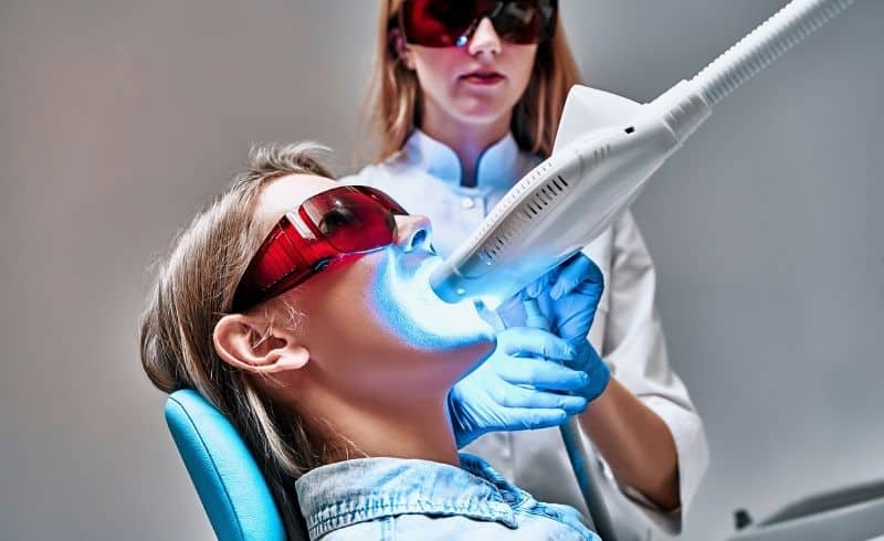 Ilustrasi gambar pasien sedang menjalani prosedur bleaching gigi di klinik