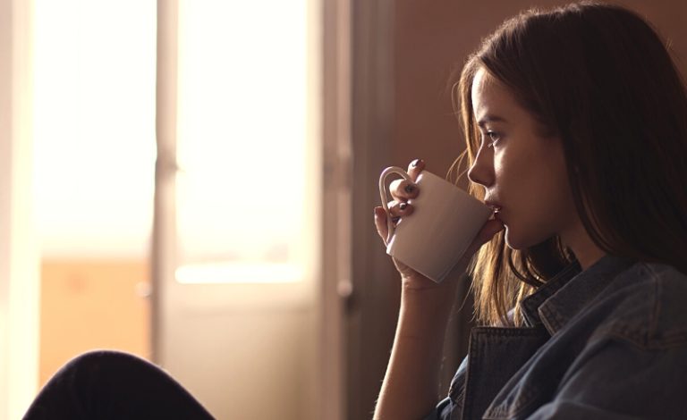 Seorang perempuan sedang minum kopi