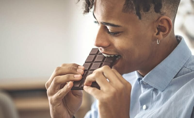 Seorang pria sedang makan coklat