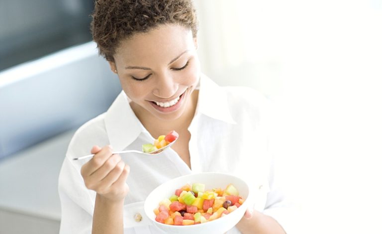 Seorang perempuan sedang makan buah