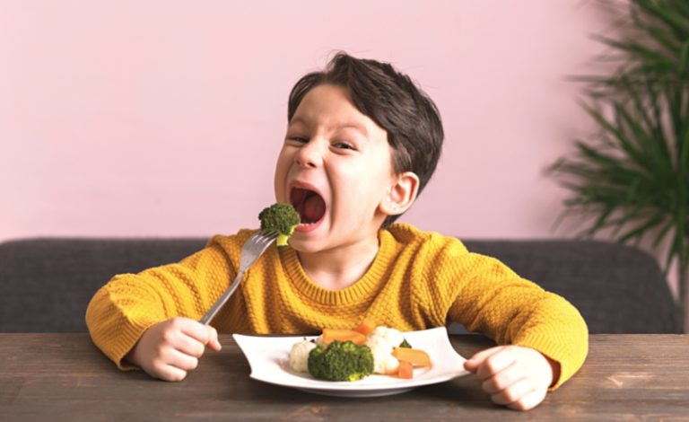 Seorang anak sedang makan sayuran