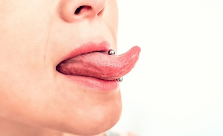 Seorang wanita menunjukkan tindik mulut di bagian lidah nya